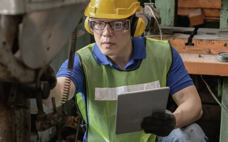 service technician in safety gear performing a maintenance check